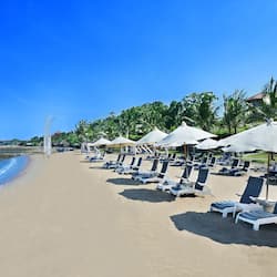 On the beach, white sand, beach cabanas, sun loungers