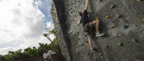 A person climbing a rock wall with various holds.