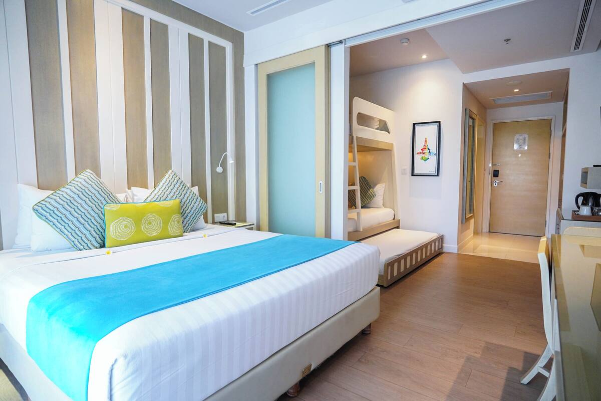 Une chambre d’hôtel avec un grand lit, un bureau et un dressing.