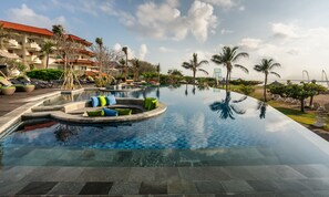 Ein Infinity-Pool mit Liegestühlen und Blick auf den Strand.