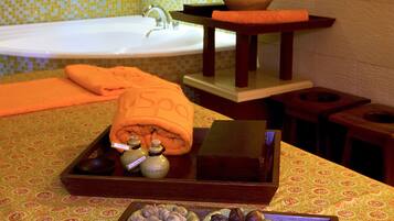 A bathroom with a bathtub, a sink, and a tray with toiletries and snacks.