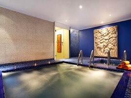 Un jacuzzi con una pared texturizada, un panel decorativo y una toalla en el borde.