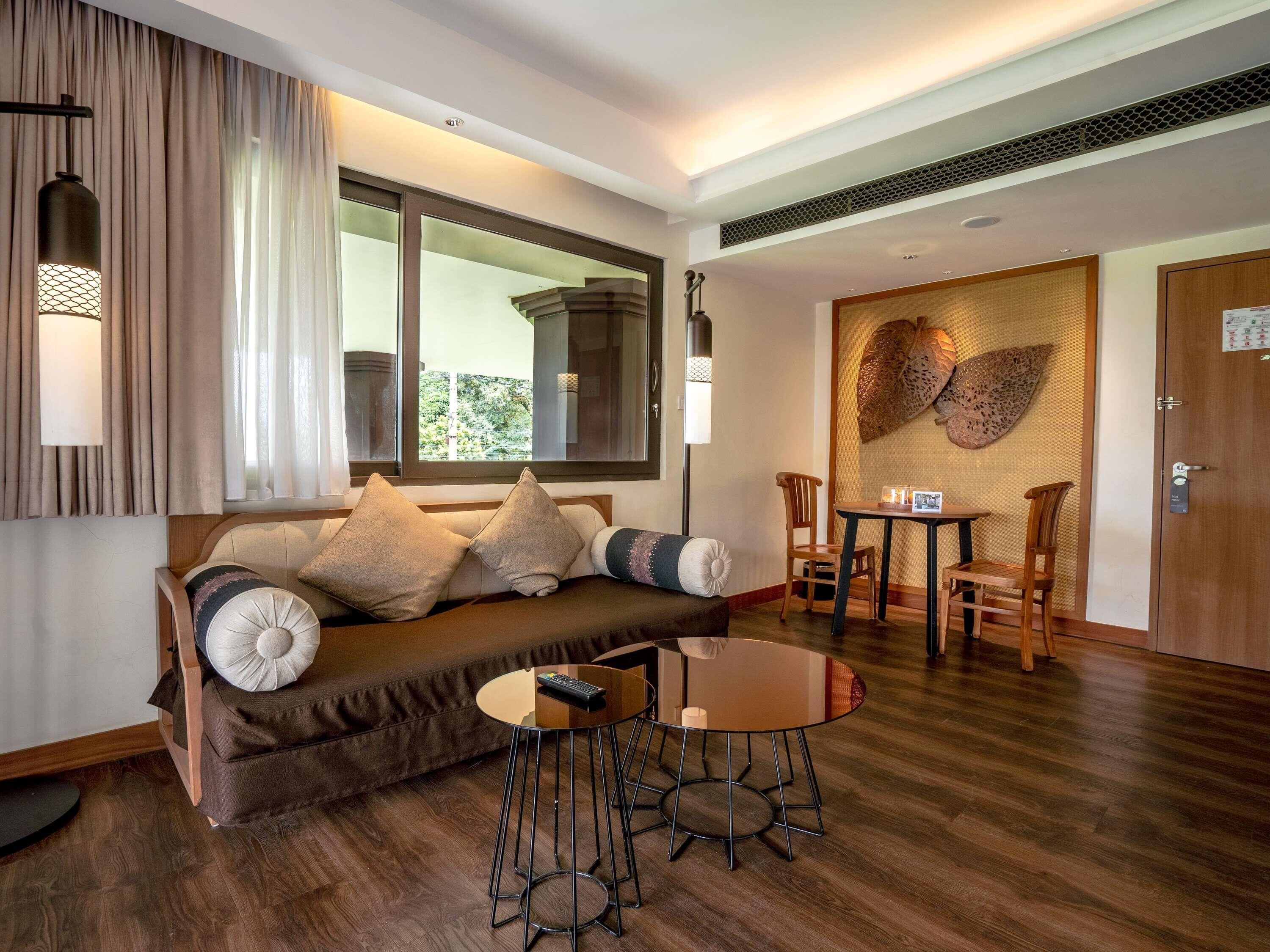Ein modernes Wohnzimmer mit einer Couch, einem runden Couchtisch und einem Esstisch mit Stühlen.