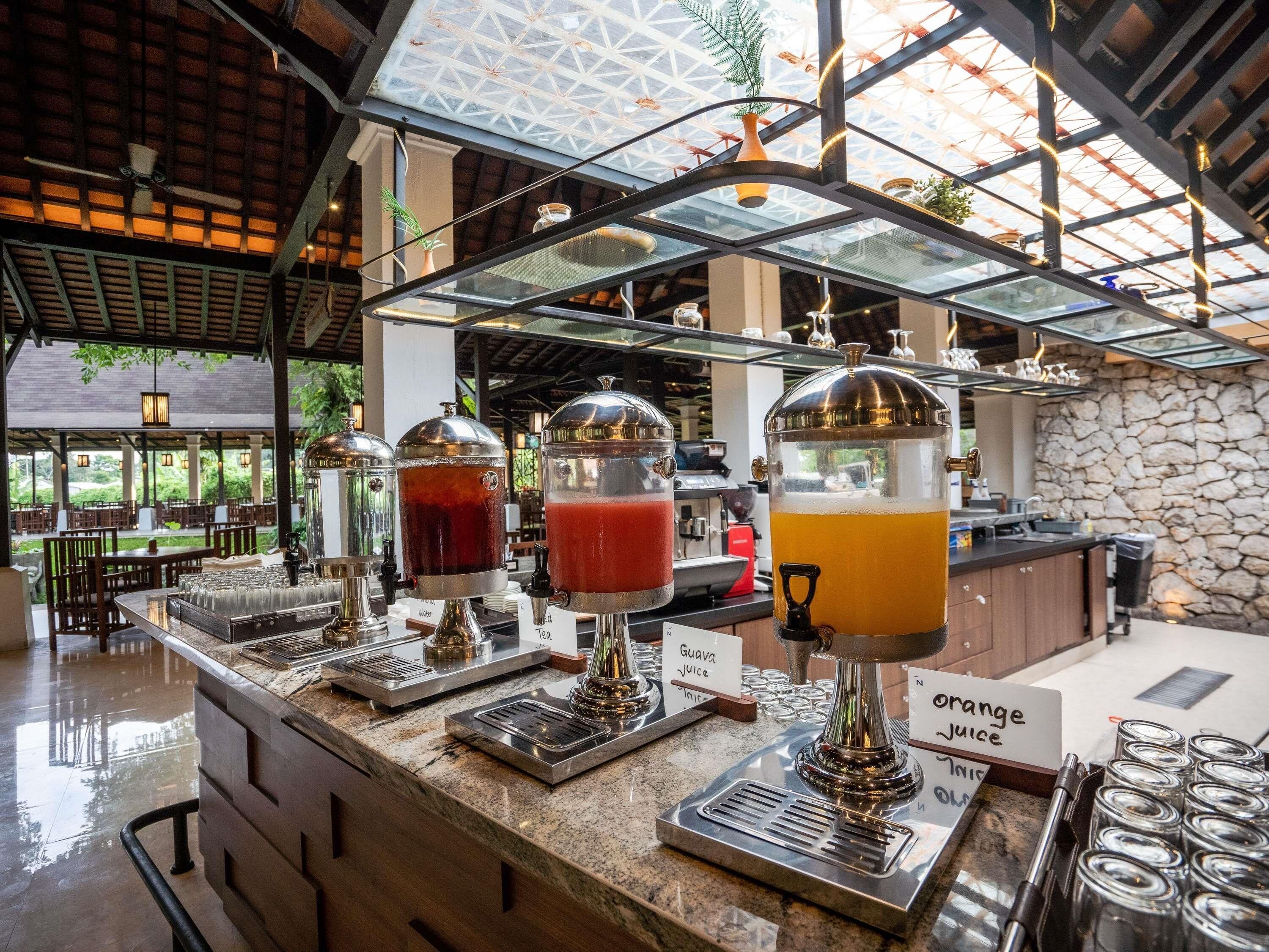 A bar area with a glass ceiling, various drink dispensers, and a stone wall.