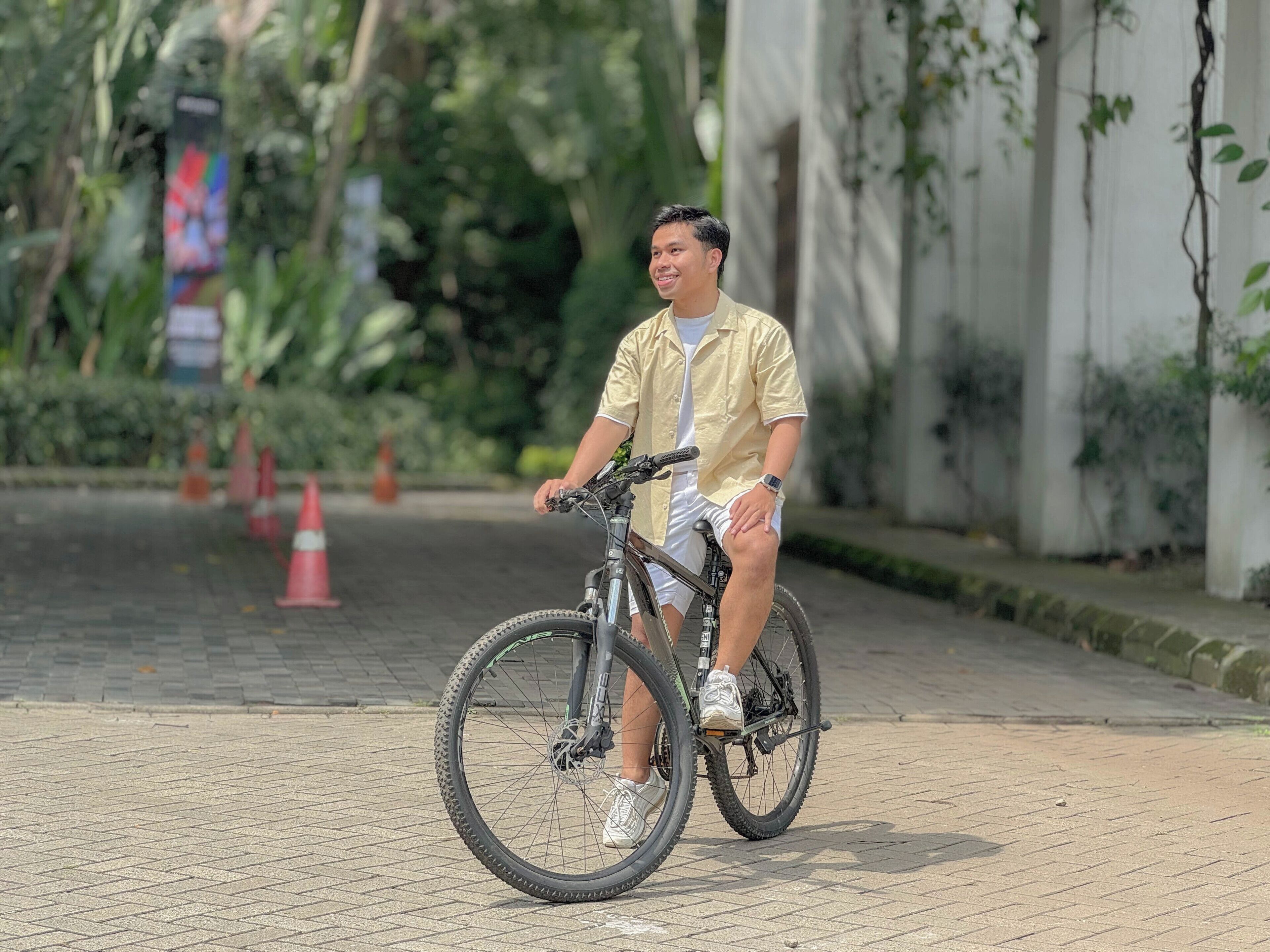 Una persona montando en bicicleta por un sendero pavimentado.