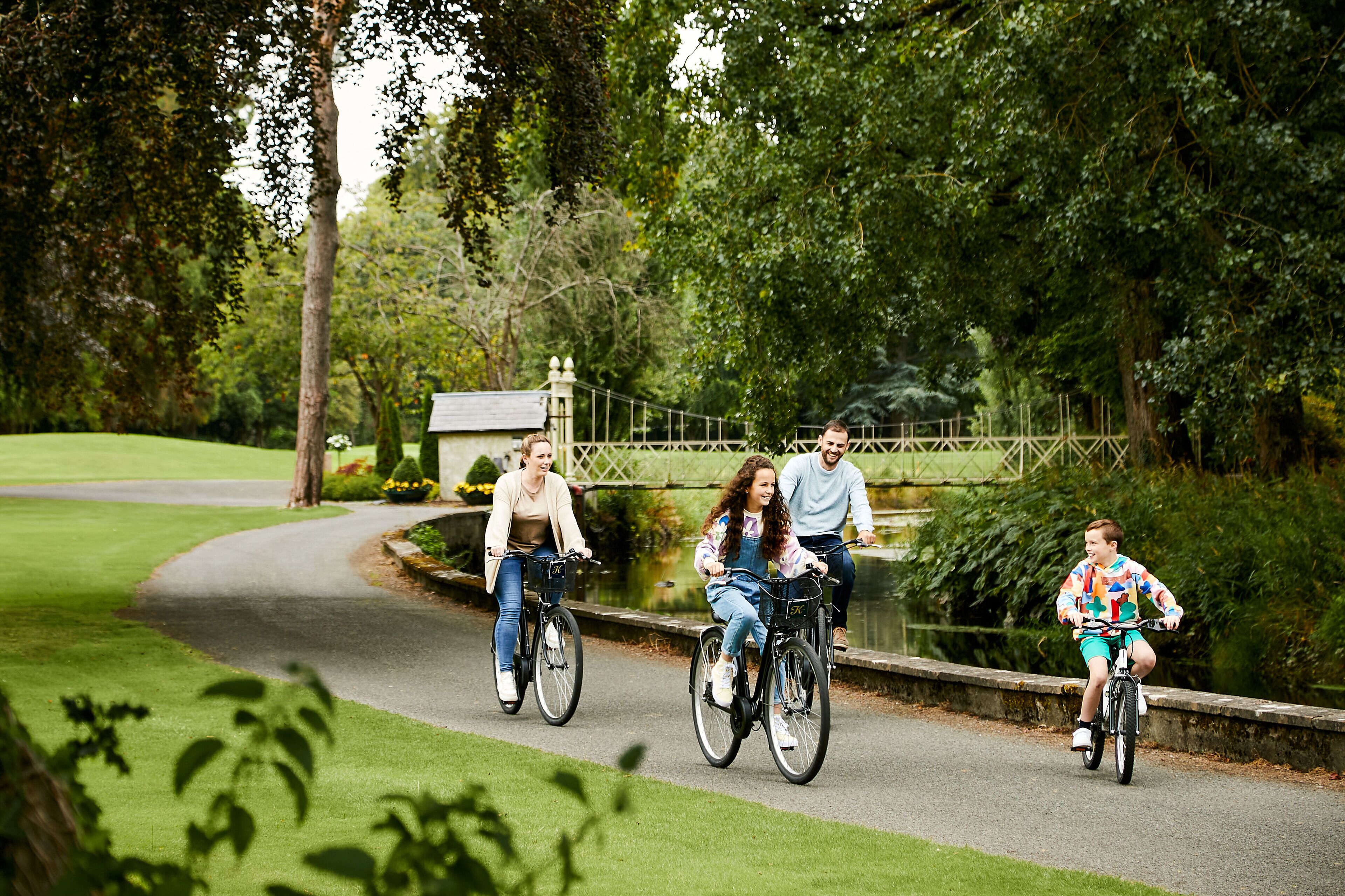 A paved pathway in a park with greenery on both sides.