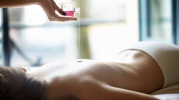 A person receiving a treatment with a liquid from a cup.