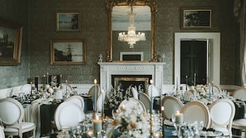 Un comedor formal con chimenea, elegantes mantelería y decoración clásica.