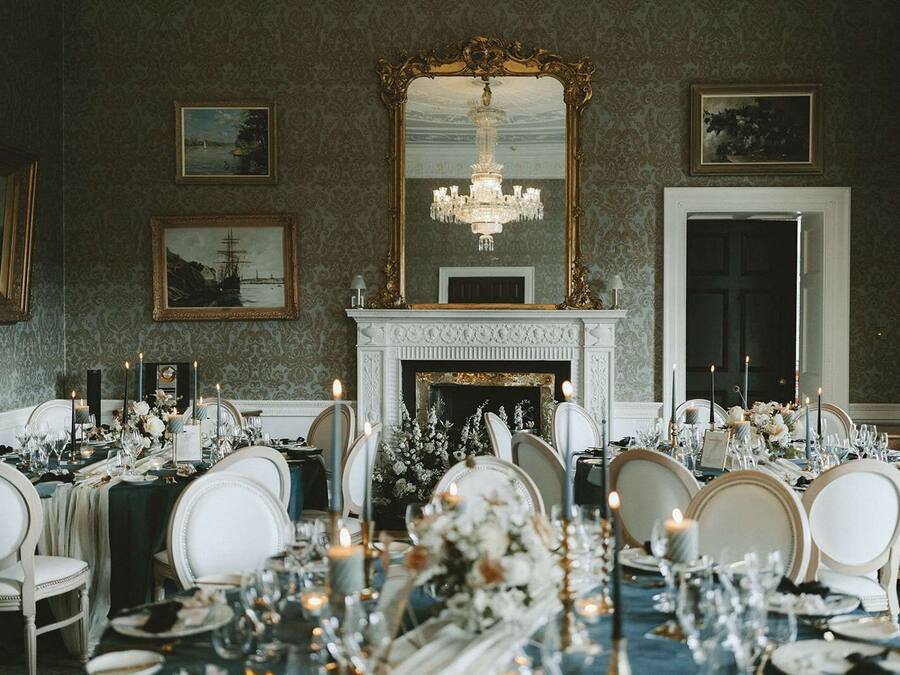 Un comedor formal con chimenea, elegantes mantelería y decoración clásica.