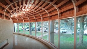 A curved hallway with large windows and a wooden ceiling structure. - Hotel delle Rose Terme & Wellnes Spa (Montechiarugolo)