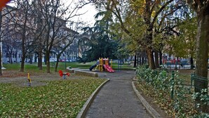 A park with a playground, a paved path, and trees. - Hotel Aspromonte (Milan)
