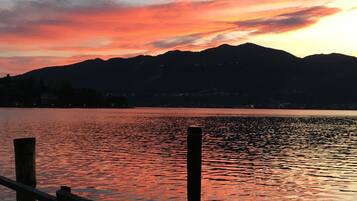 A sunset over a calm lake with mountains in the background.