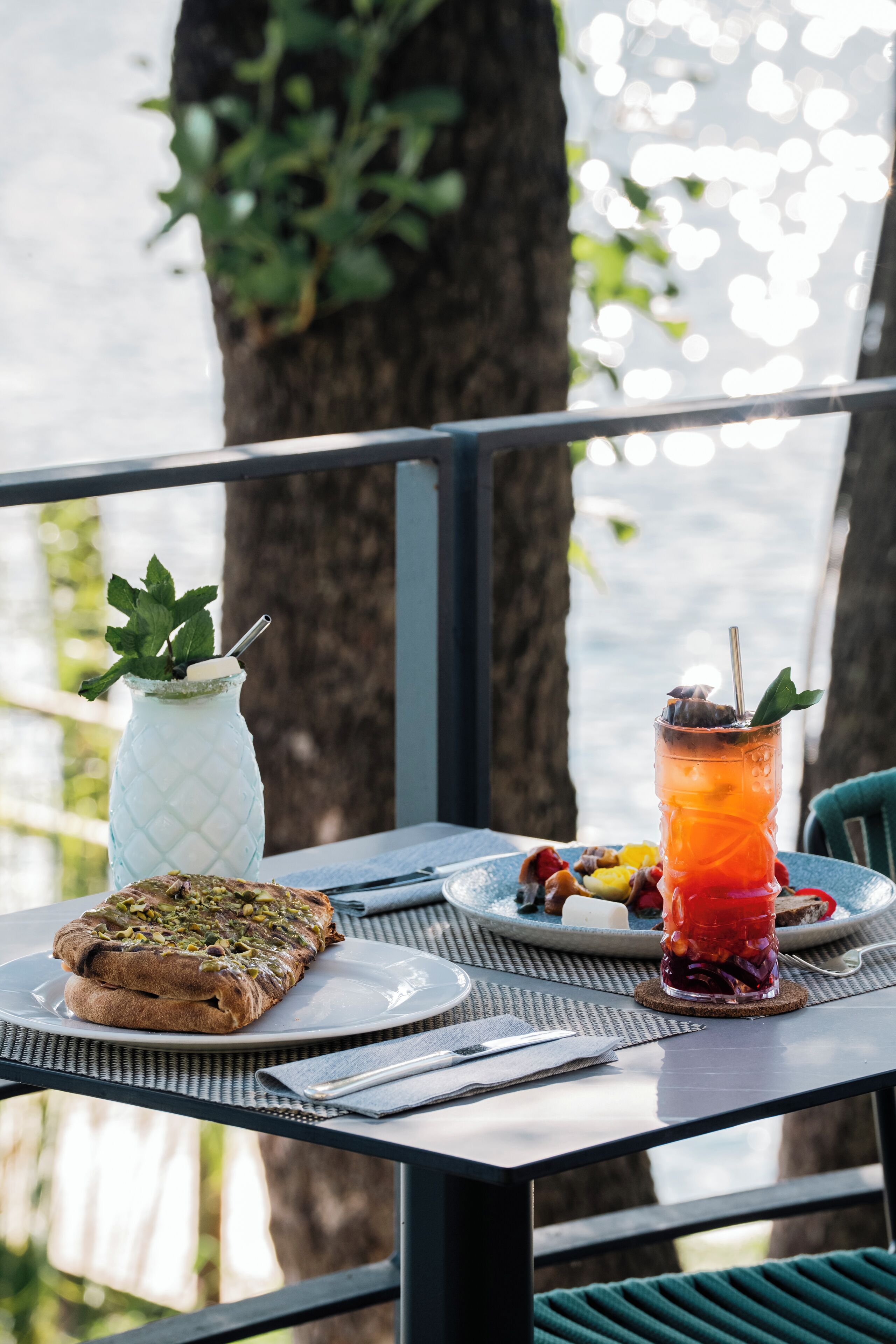 Une table avec une assiette de nourriture, une boisson et un vase décoratif.