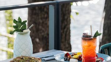 Une table avec une assiette de nourriture, une boisson et un vase décoratif.