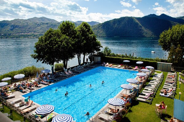 Una piscina al aire libre, sillones reclinables de piscina