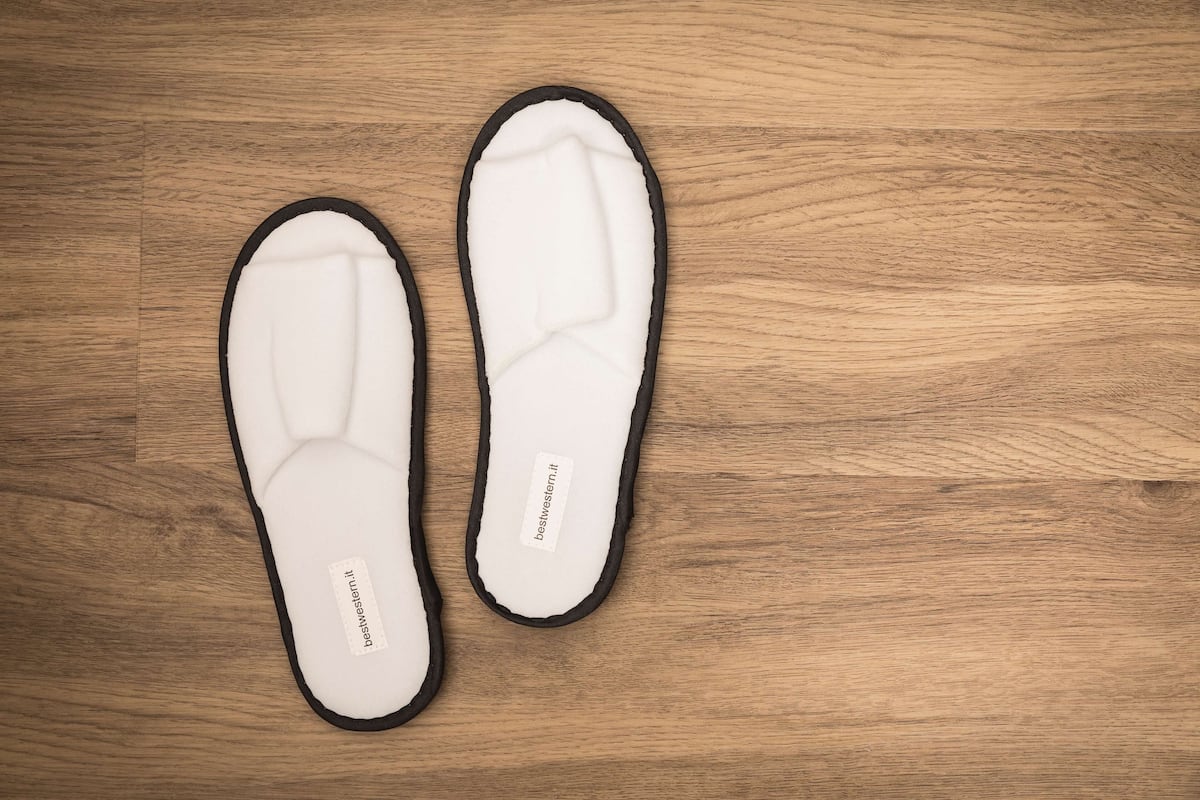 Un par de zapatillas blancas con detalles negros y una etiqueta en la suela.