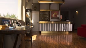 Cozinha moderna com piso de madeira, ilha central com bancada listrada e uma cadeira vermelha em primeiro plano.