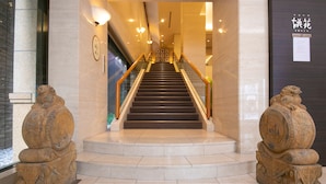 Un magnifique escalier en marbre, avec des marches de marbre et des rampes dorées, flanqué de sculptures en pierre richement décorées.