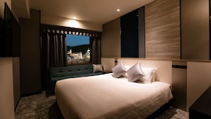 Une chambre d’hôtel moderne dotée d’un grand lit, d’un coin salon et offrant une vue sur la ville.