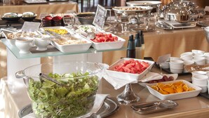 Una mesa de buffet con diversos alimentos y utensilios.