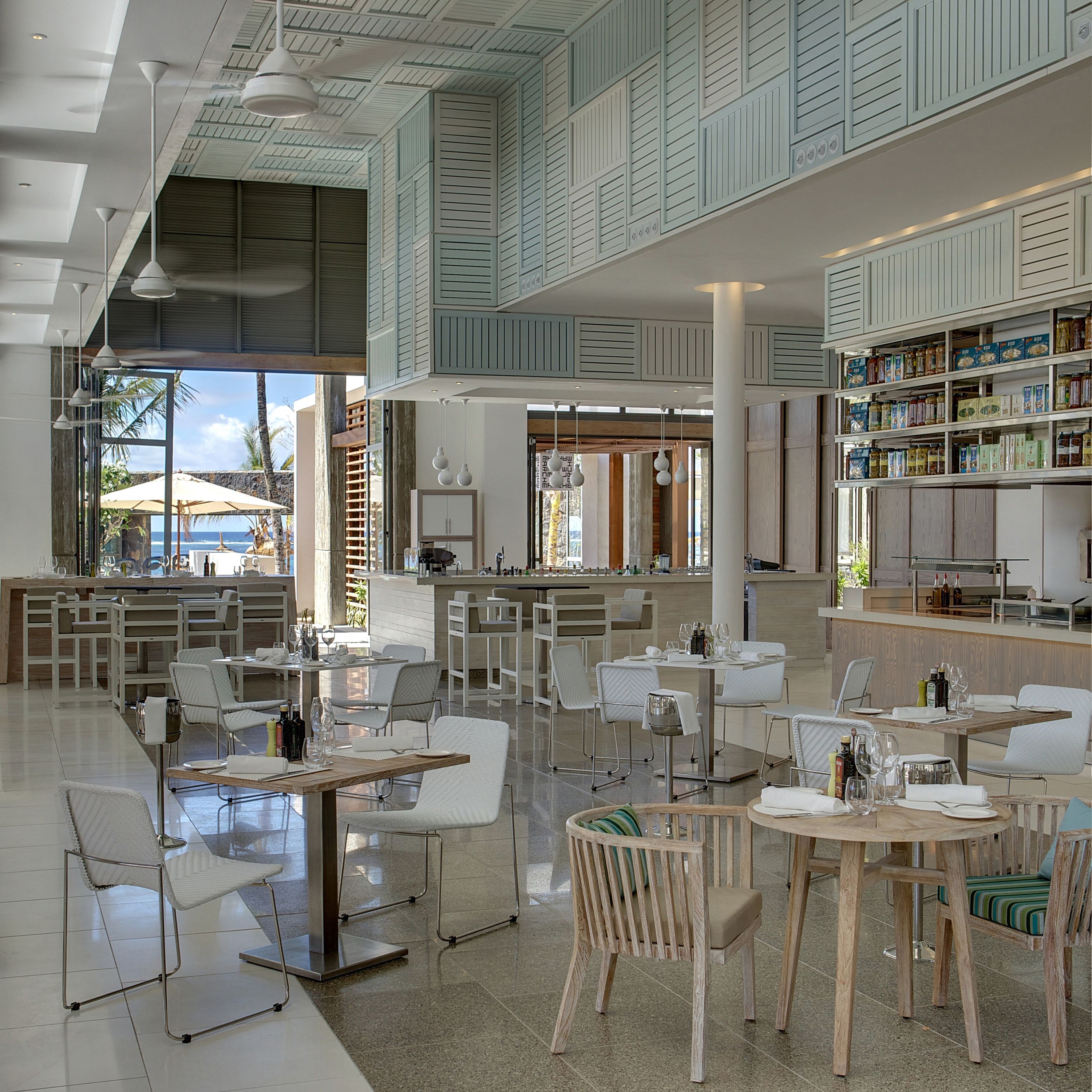 A spacious, modern hotel lobby with high ceilings, a central bar area, and seating arrangements.