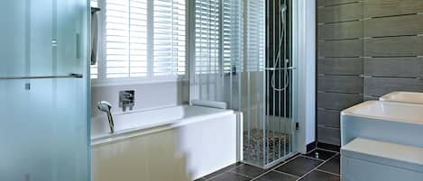 A modern bathroom with a bathtub, shower, and toilet.