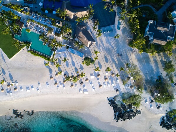 On the beach, white sand, sun-loungers, beach umbrellas