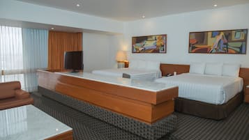 Una habitación de hotel con una cama grande, un escritorio, una silla y dos cuadros en la pared.