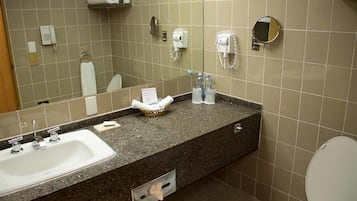 A bathroom with a sink, mirror, towel rack, and hairdryer.