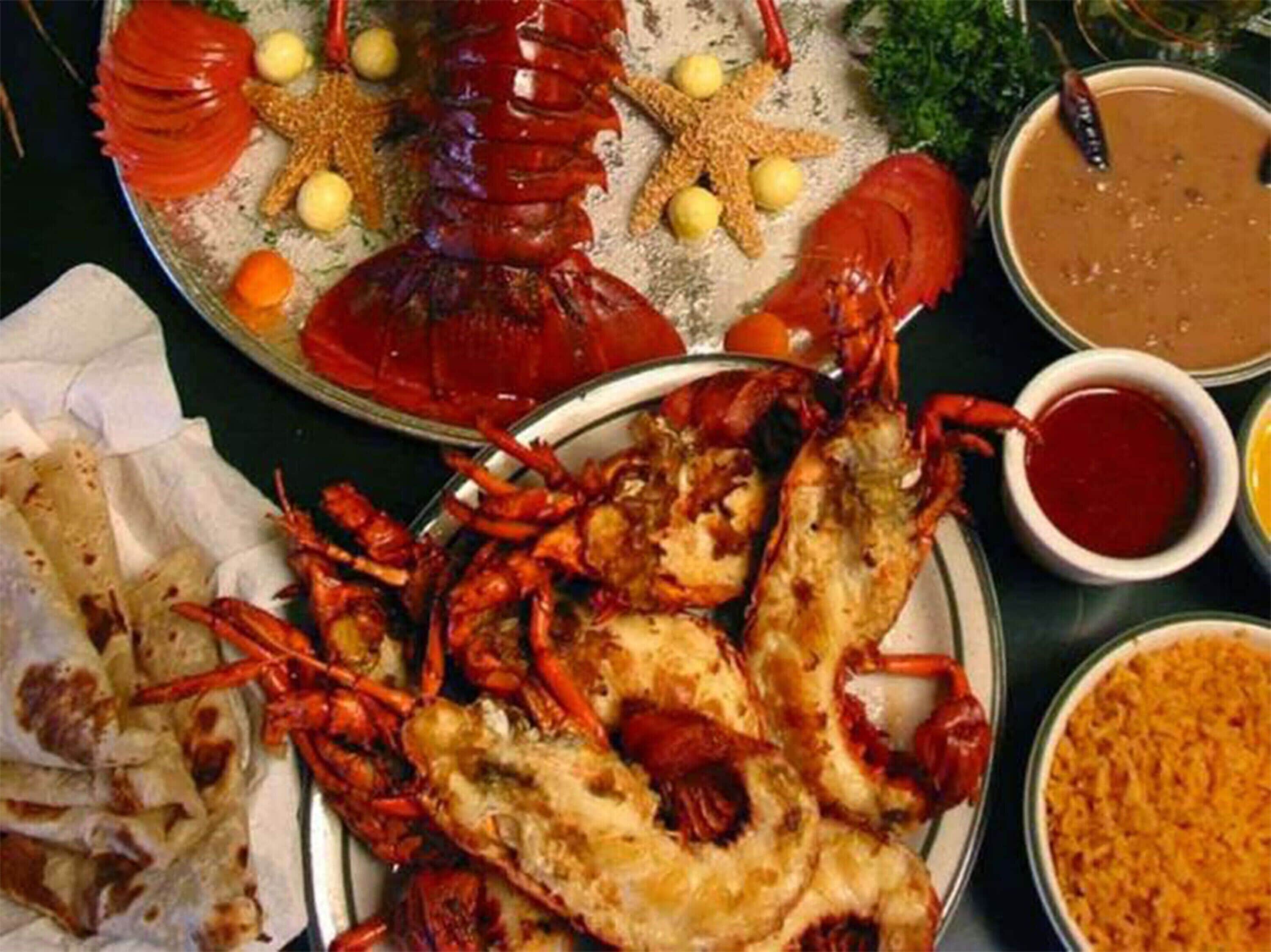 A seafood platter with lobster, shrimp, and various sides.