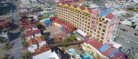 A multi-story hotel with a pool area and a view of the surrounding cityscape.