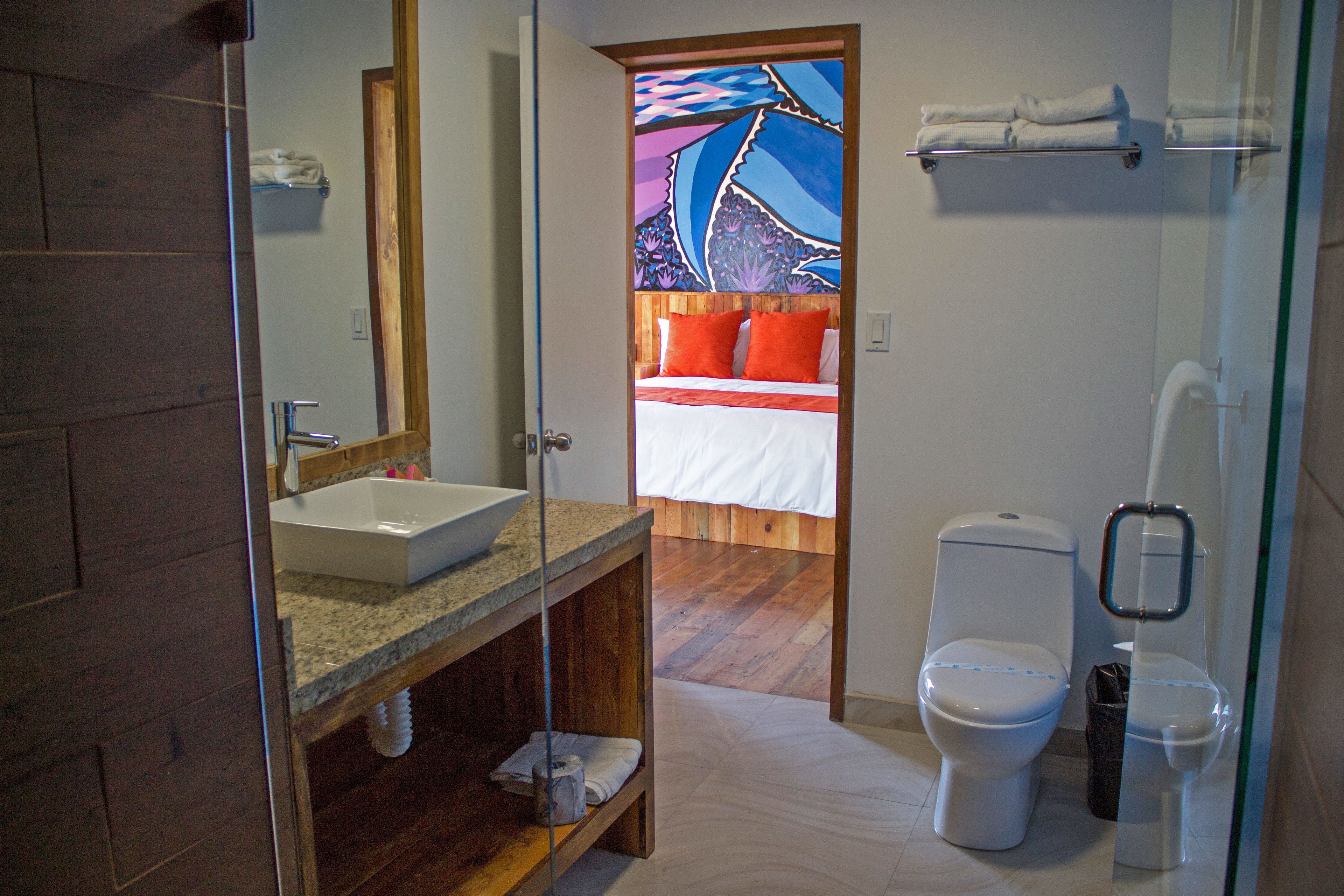 Un bagno con un mobile lavabo in legno, un lavandino e un water.