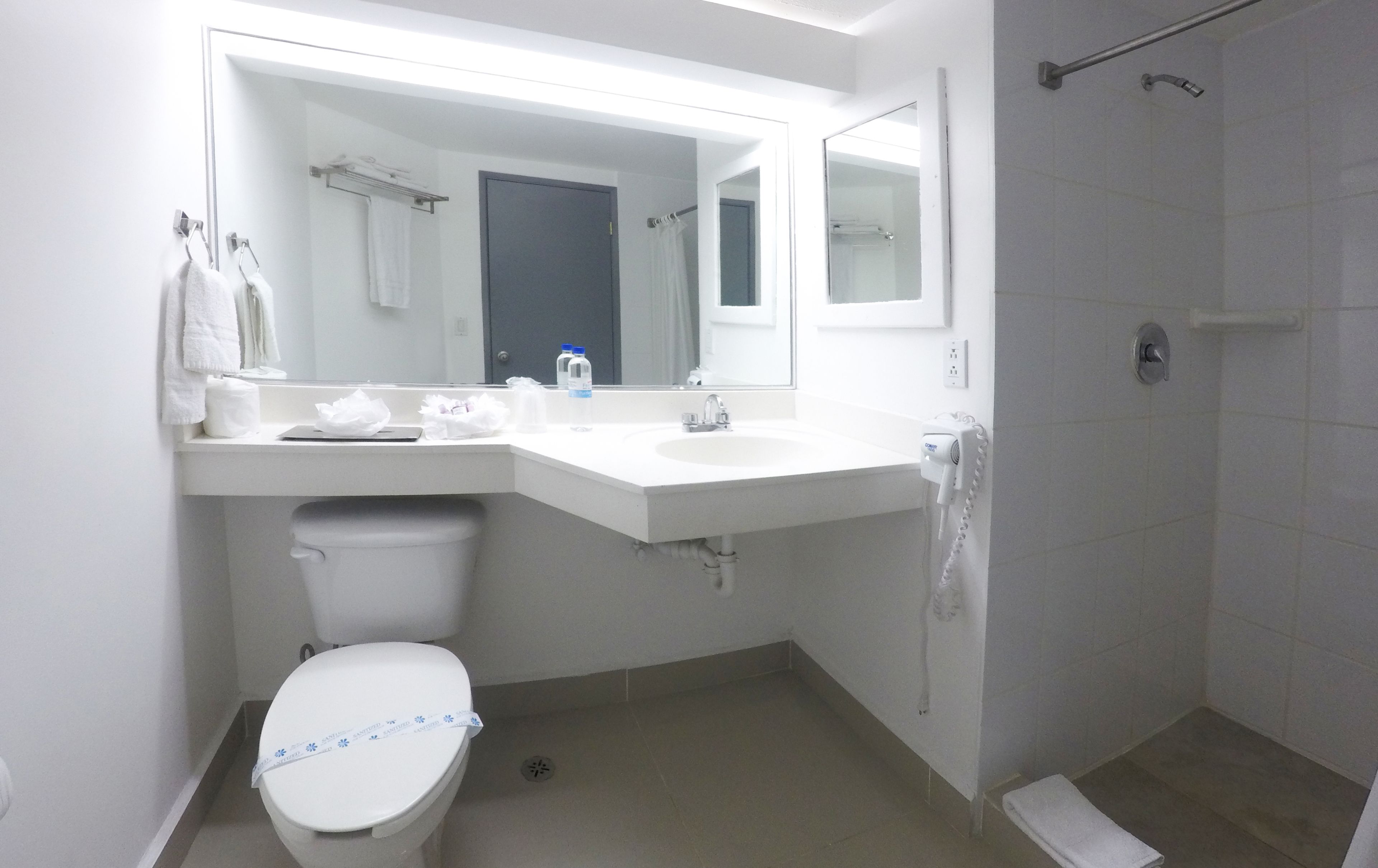 A modern bathroom with a toilet, sink, and shower.
