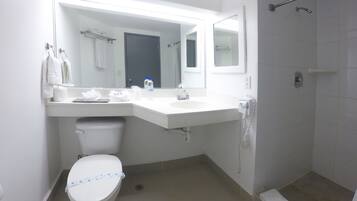 Un baño moderno con inodoro, lavamanos y ducha.