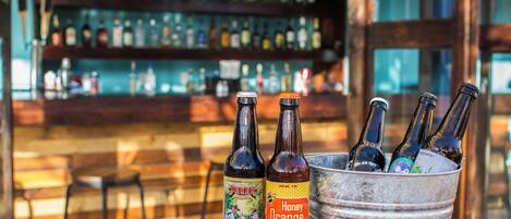 A bar setting with bottles in a bucket and a shelf with various bottles in the background.
