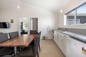 A modern kitchen with white cabinets, a granite countertop, and a built-in dishwasher.