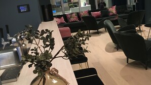 A modern office space with a reception area, seating, and a coffee machine.