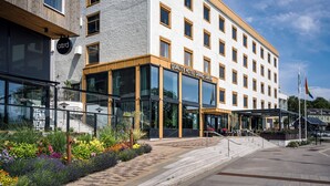 Un hotel moderno con fachada blanca, múltiples ventanas y un letrero que dice "Quality Hotel Grand Carvik".