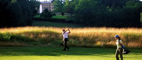 A golf course with a building in the background.