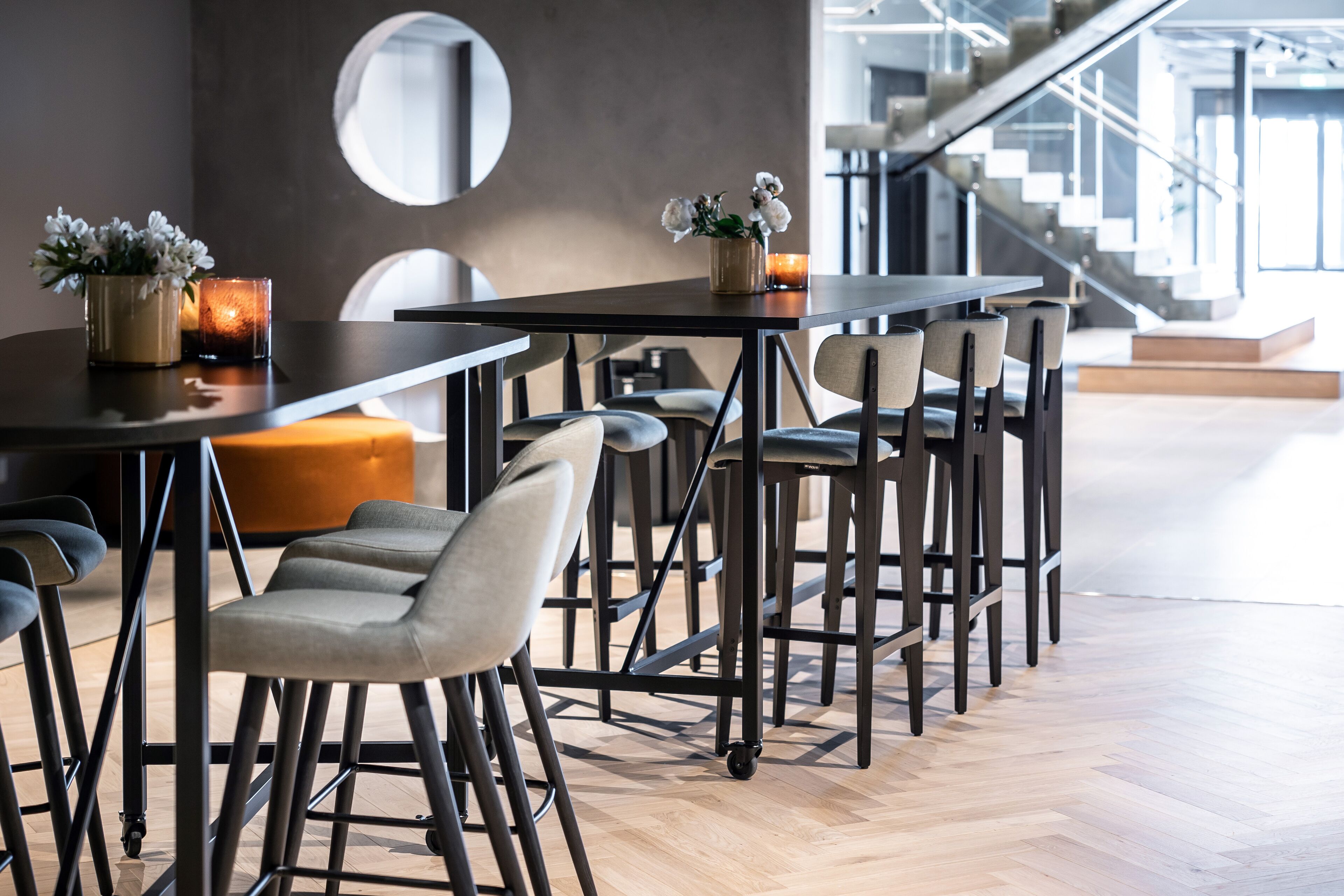 Uma sala de jantar moderna com uma mesa comprida, várias cadeiras e um pequeno vaso de planta.