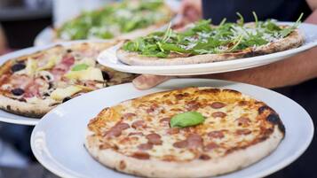 Three pizzas on white plates, each with different toppings.