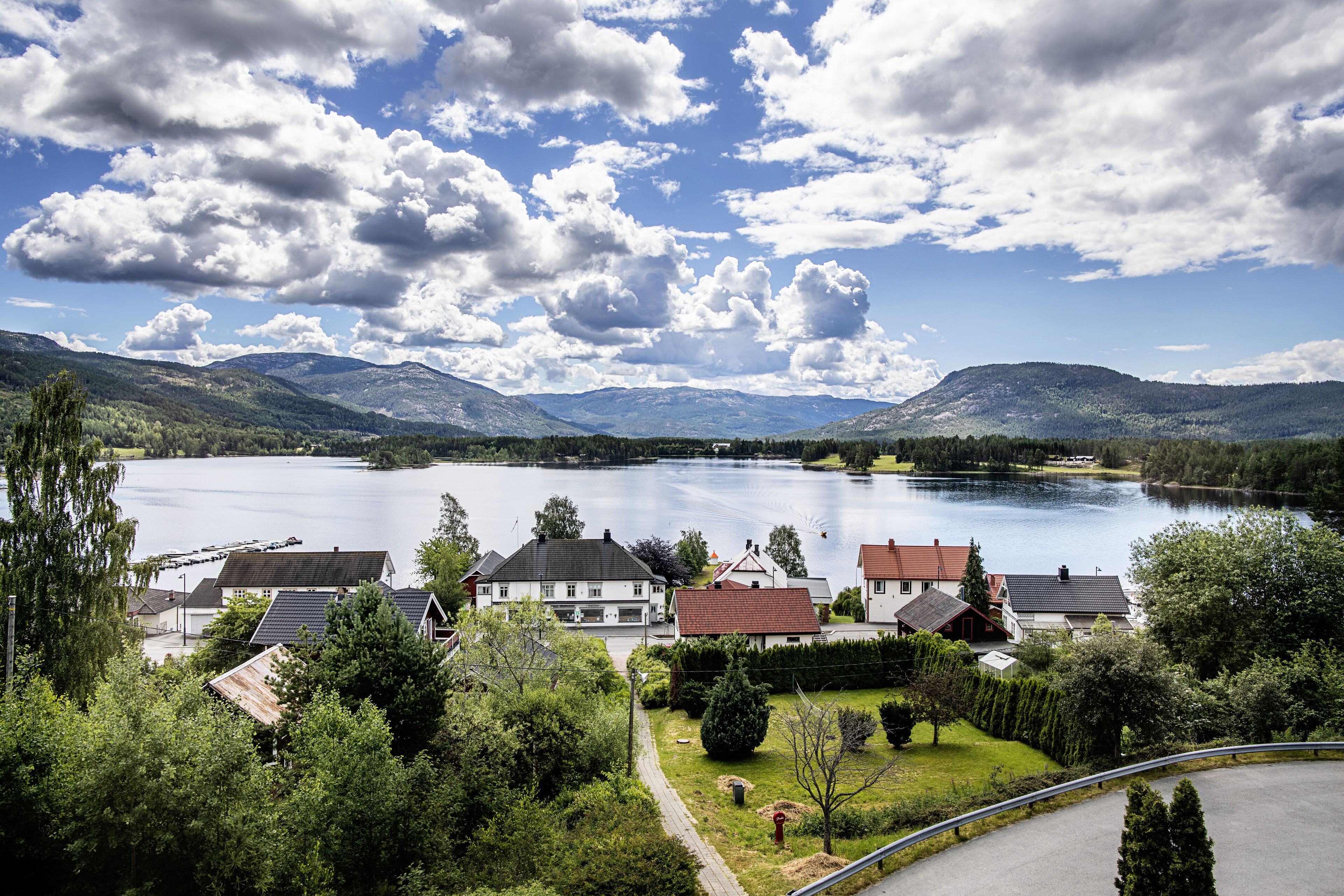En utsikt över en sjö med hus, en väg och en klar himmel.