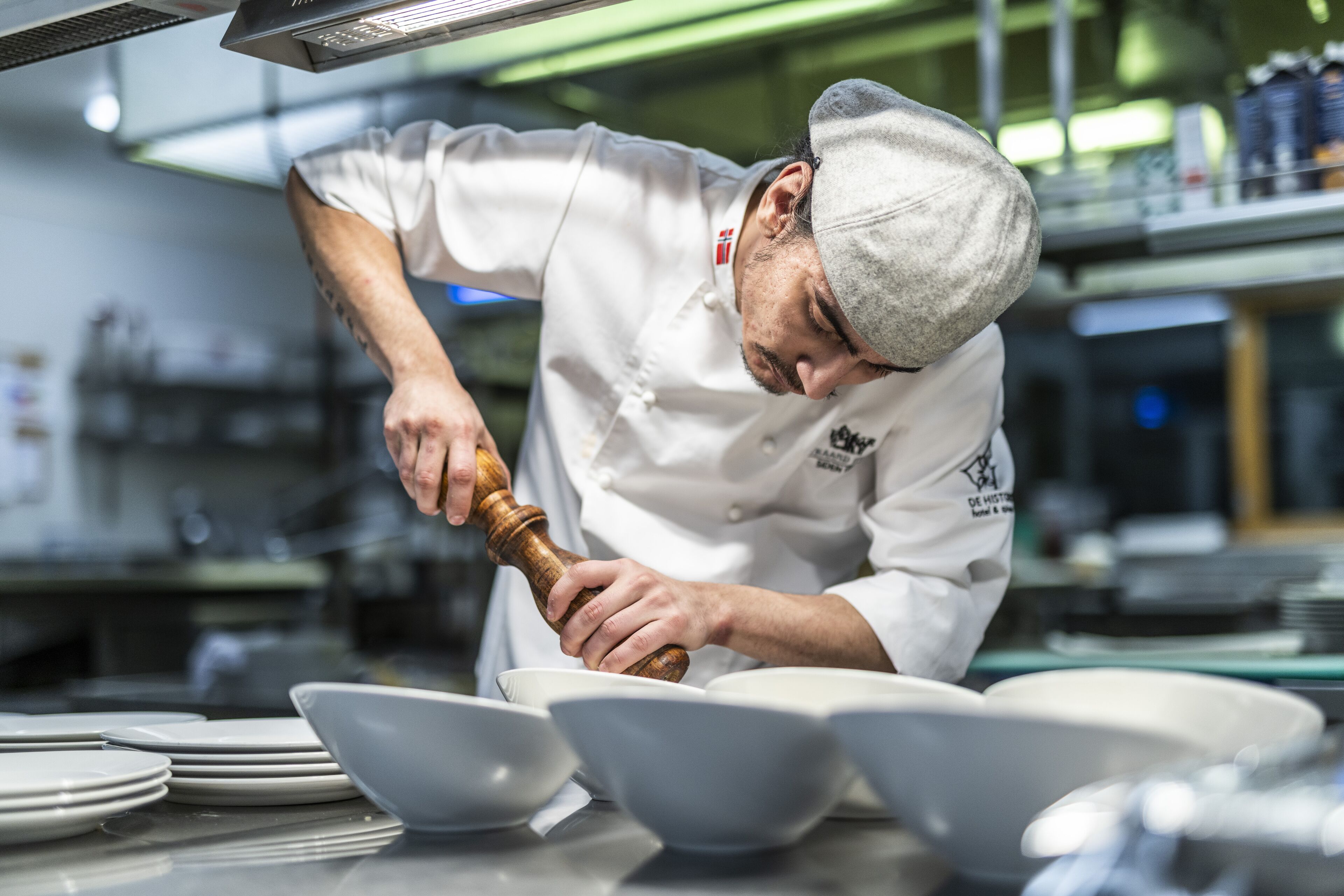 A chef in a professional kitchen, preparing food.