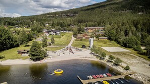 A lakeside village with a dock, boats, and a floating platform. - Straand Hotel (Kviteseid)