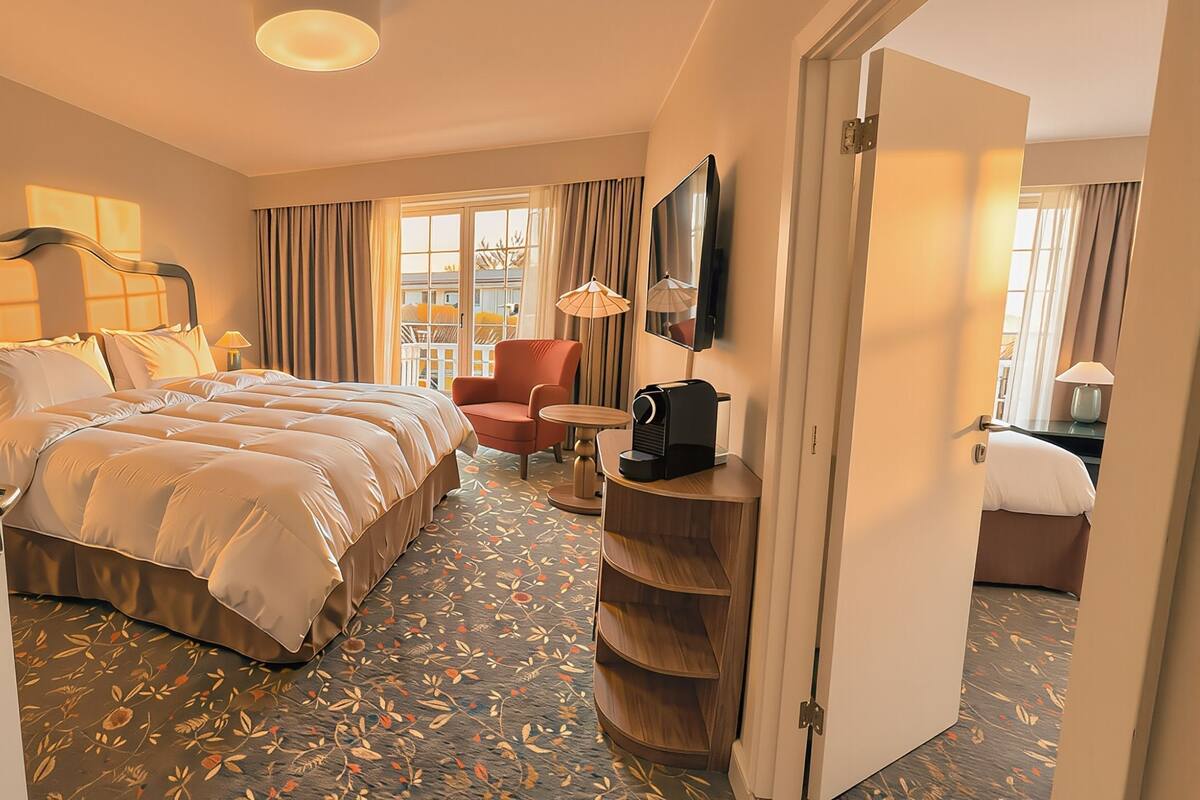 Une chambre d’hôtel avec un grand lit, une chaise, une télévision, une machine à café et une armoire.