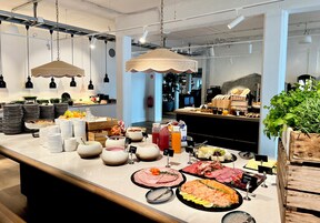 Una mesa de buffet con diversos alimentos y utensilios.