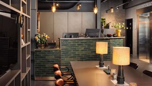 A modern kitchen with a long dining table, a bar area, and a refrigerator. - Scandic Sarpsborg (Sarpsborg)
