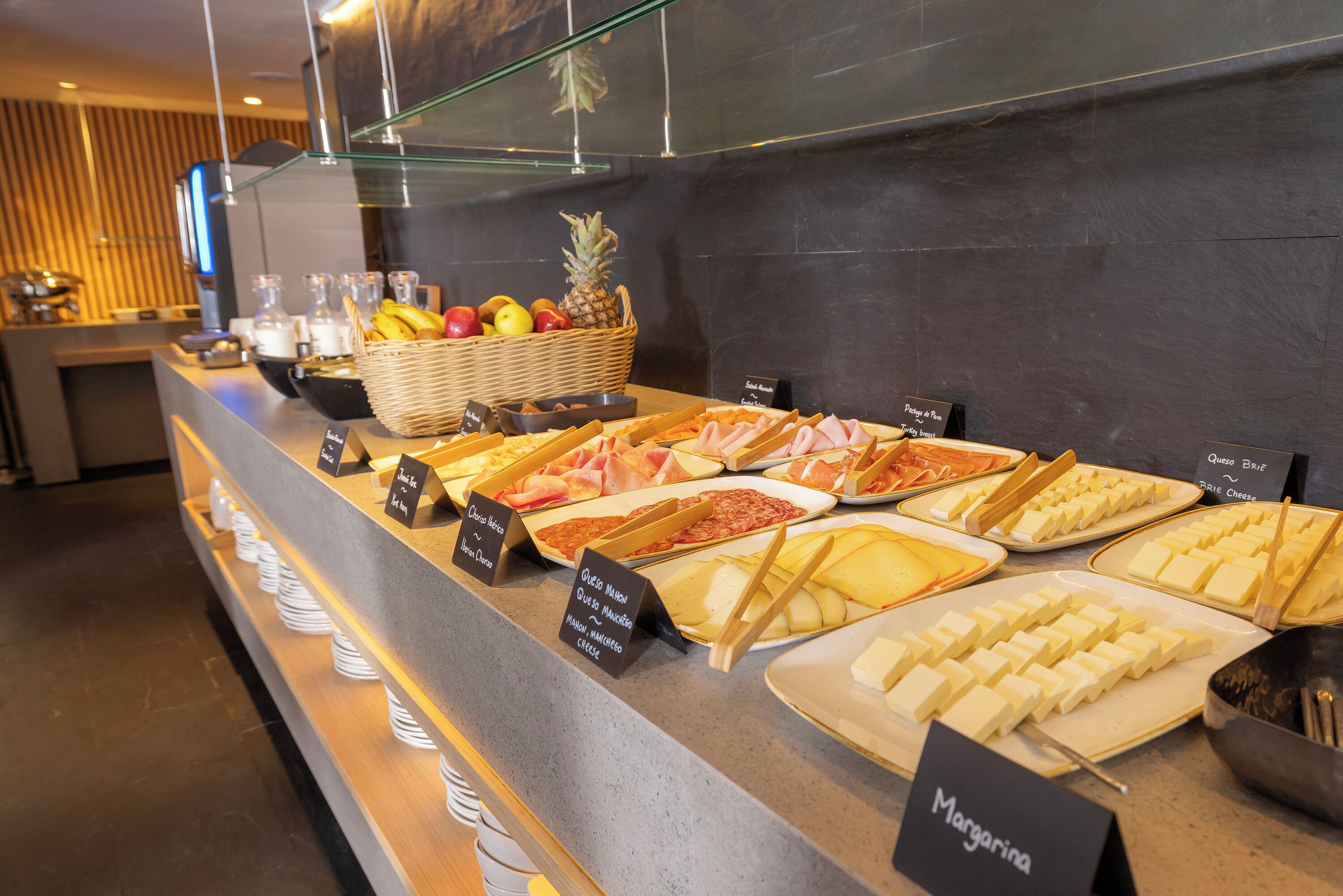 Ein reichhaltiges Buffet mit einer Auswahl an Speisen, darunter Käse, Fleisch und Obst.