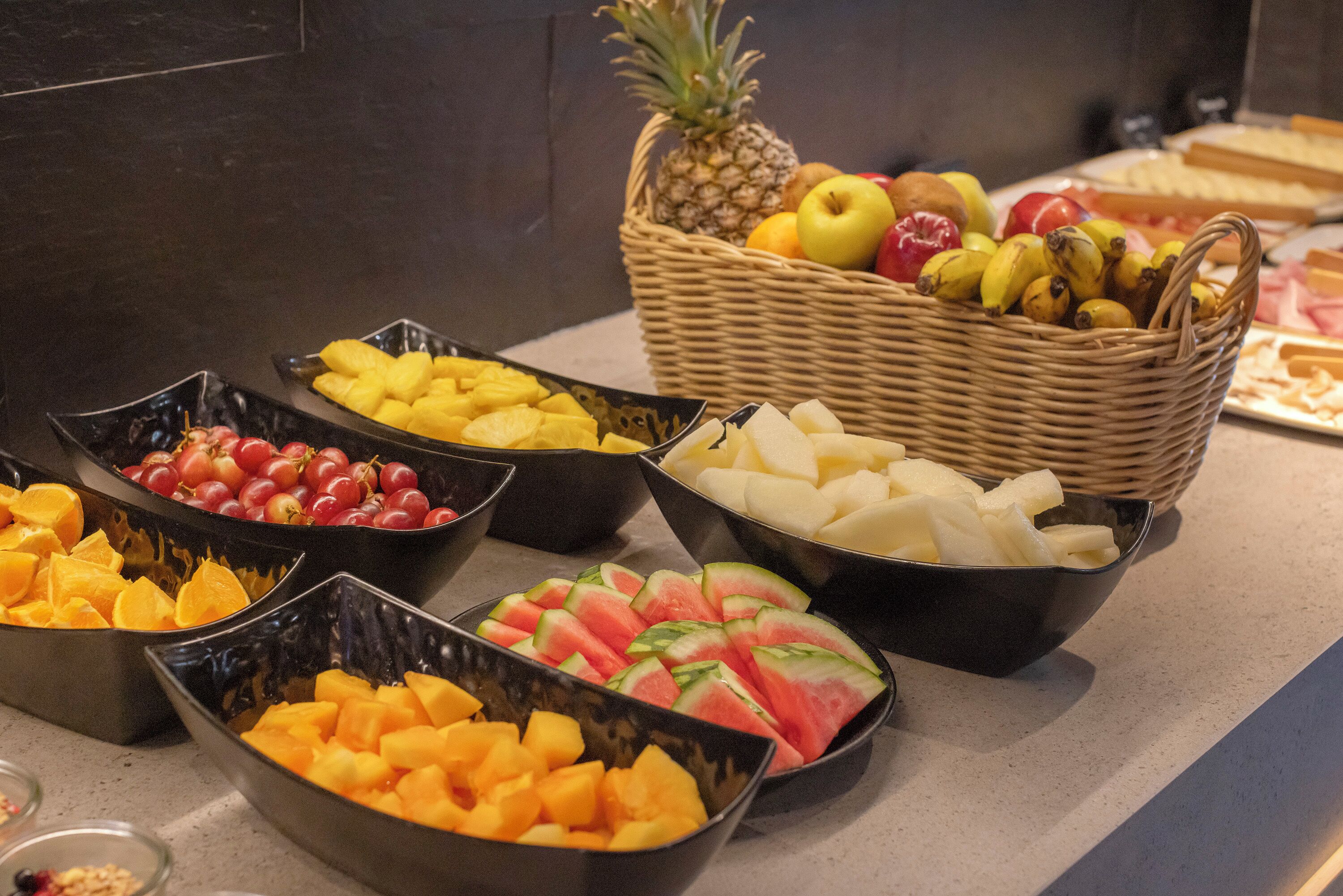 Un bufé con diversas frutas y quesos.