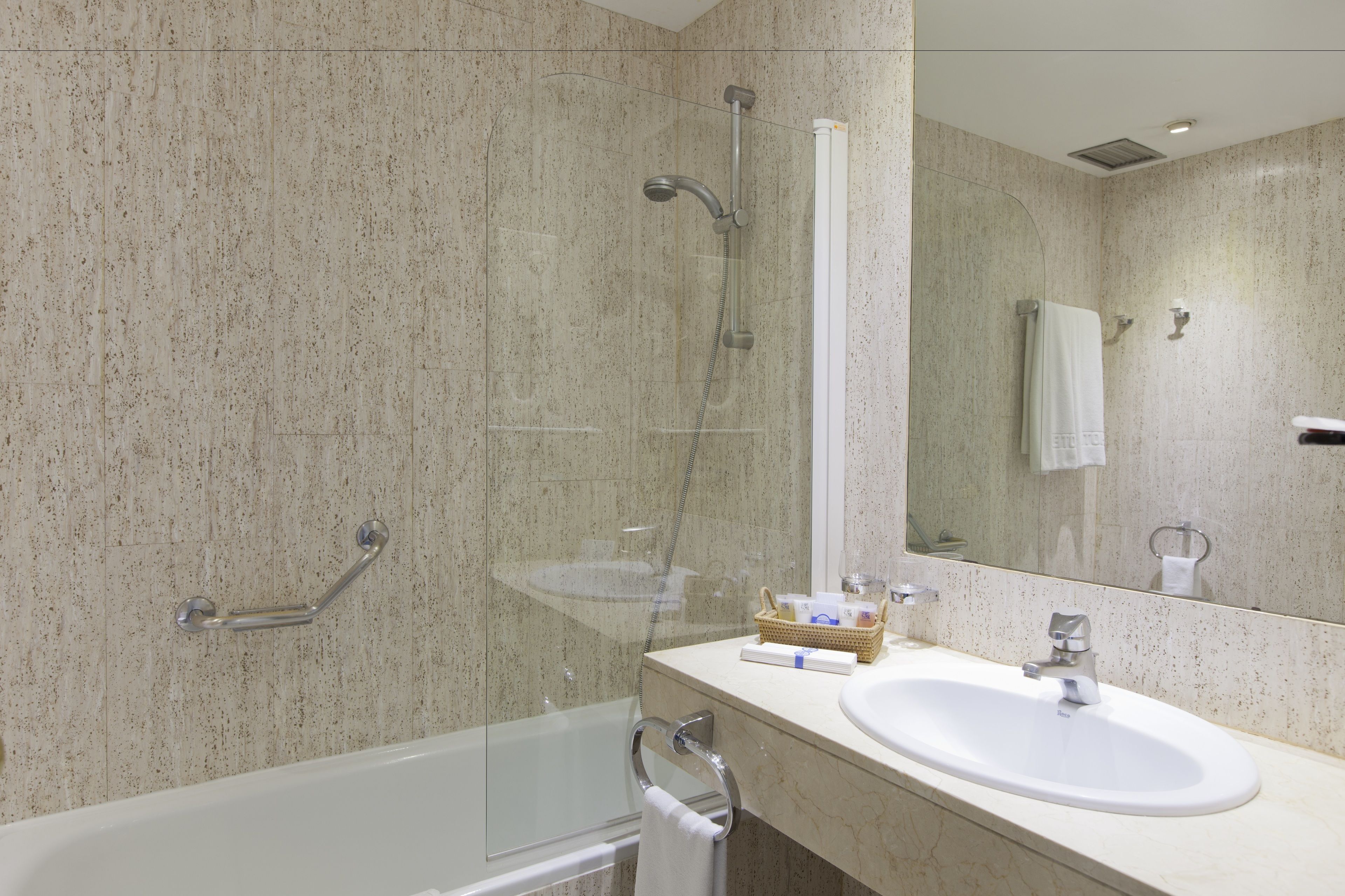 A modern bathroom with a bathtub, a sink, a shower, and a mirror.